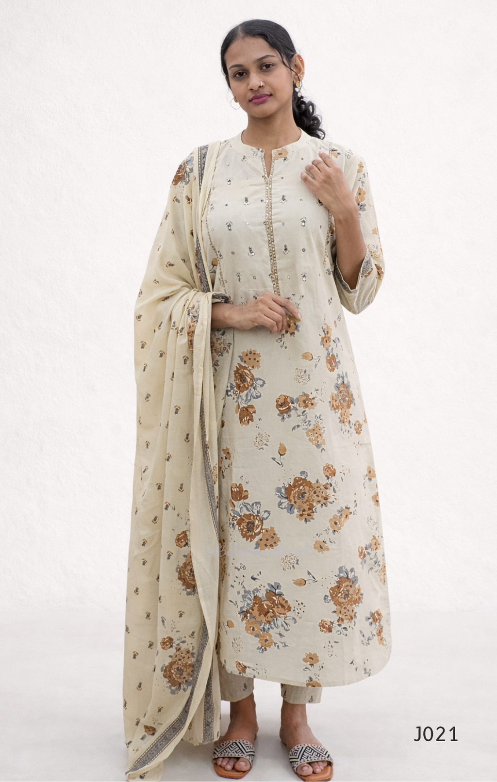 Woman wearing a floral kurta with a dupatta on a white background