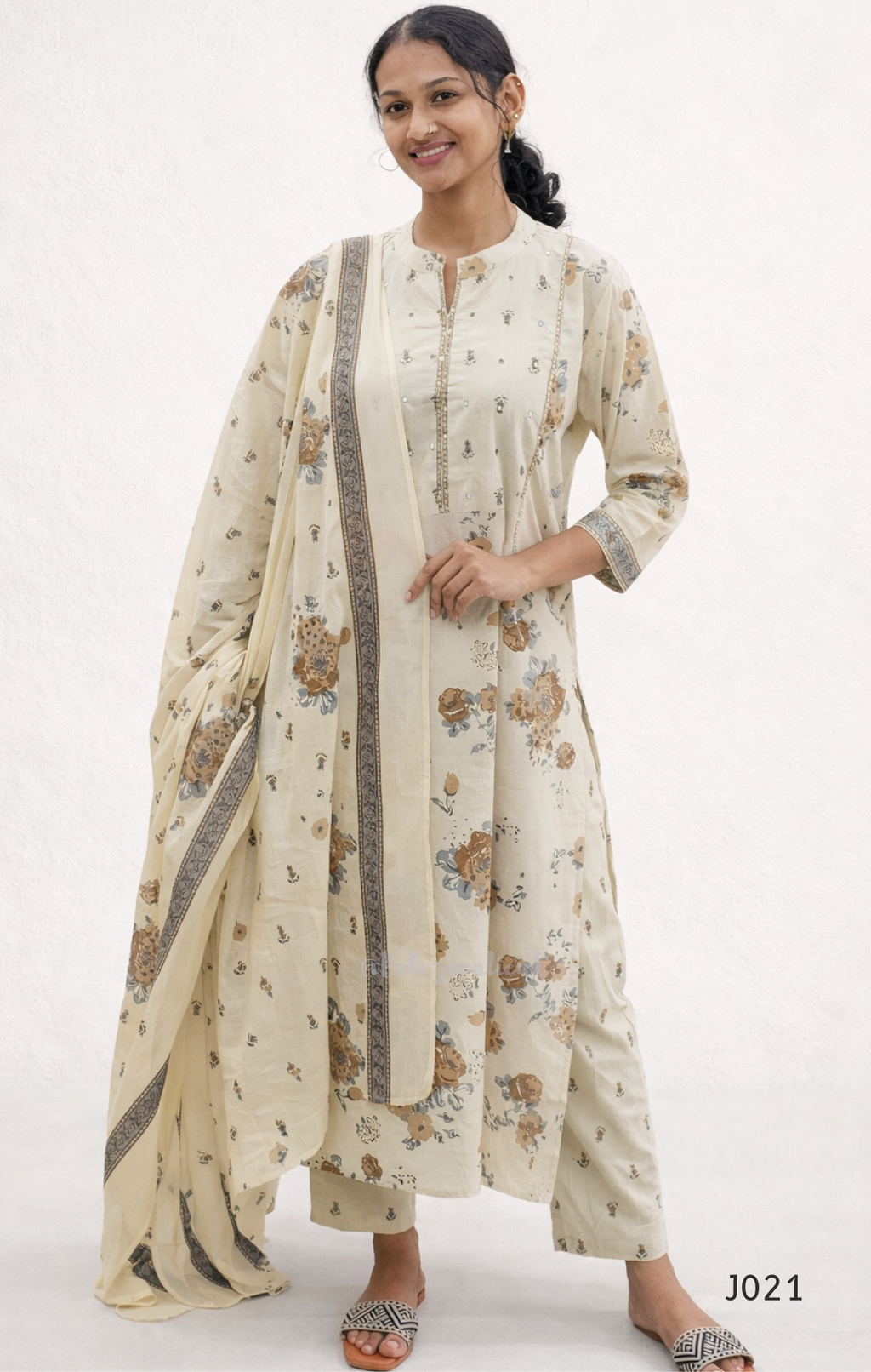 Woman wearing a floral kurta with a matching dupatta on a white background
