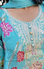 Close-up of a turquoise embroidered garment with floral patterns