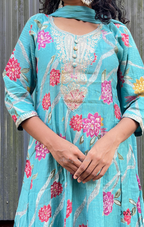 Person wearing a light blue embroidered dress with pink floral patterns.