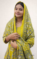 Woman wearing a yellow and green traditional outfit with a matching scarf on a white background