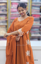 Woman wearing an orange dress with white floral patterns in a store setting