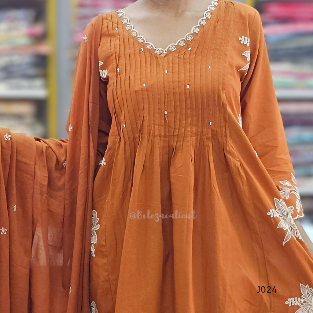 Orange dress with white embroidery in a store setting