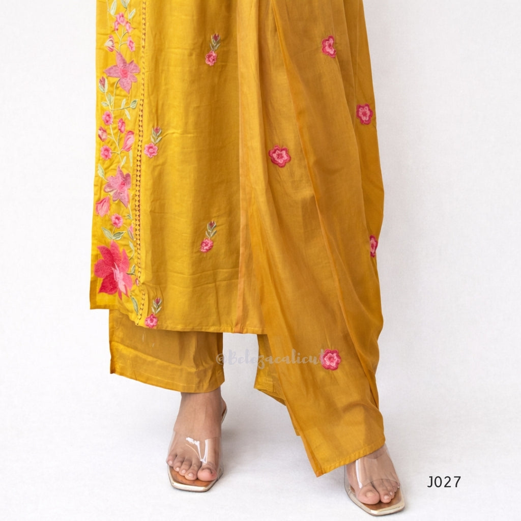Mustard yellow outfit with floral embroidery on a white background
