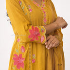 Yellow dress with pink floral embroidery on a white background