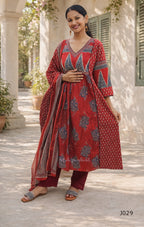 Woman wearing a red and blue patterned outfit standing outdoors.