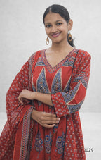 Woman wearing a red patterned dress against a white background