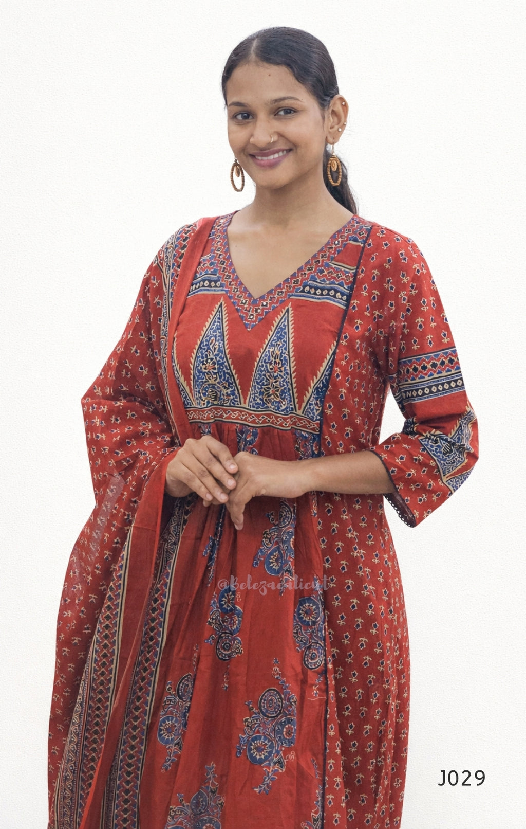 Woman wearing a red patterned dress on a white background