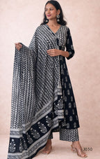 Woman wearing a black and white patterned outfit with a matching dupatta on a beige background