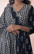 Person wearing a black and white patterned outfit with a close-up of the fabric.