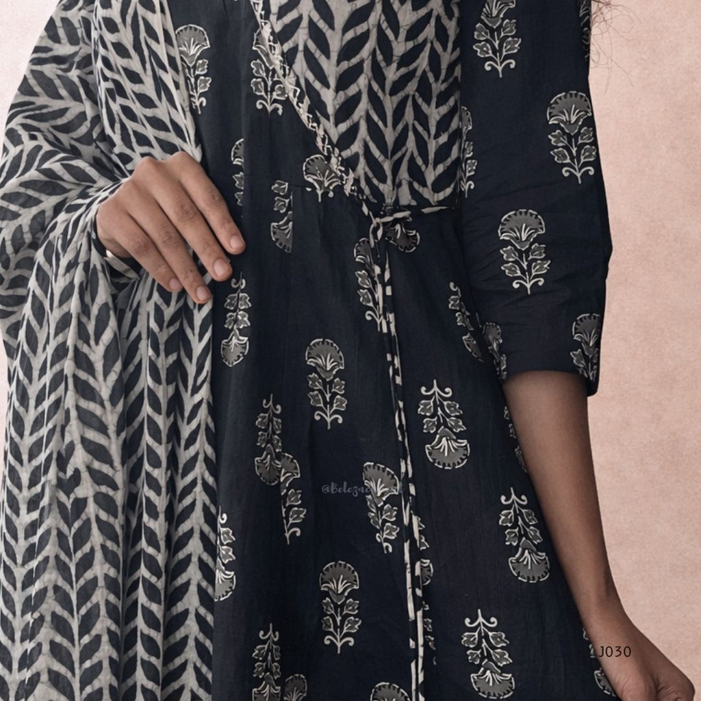 Black and white patterned fabric with floral designs on a pink background