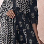 Black and white patterned fabric with floral designs on a pink background