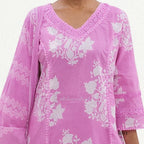 Pink embroidered garment with white patterns on a white background