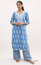 Woman wearing a blue patterned kurta with white embroidery on a white background