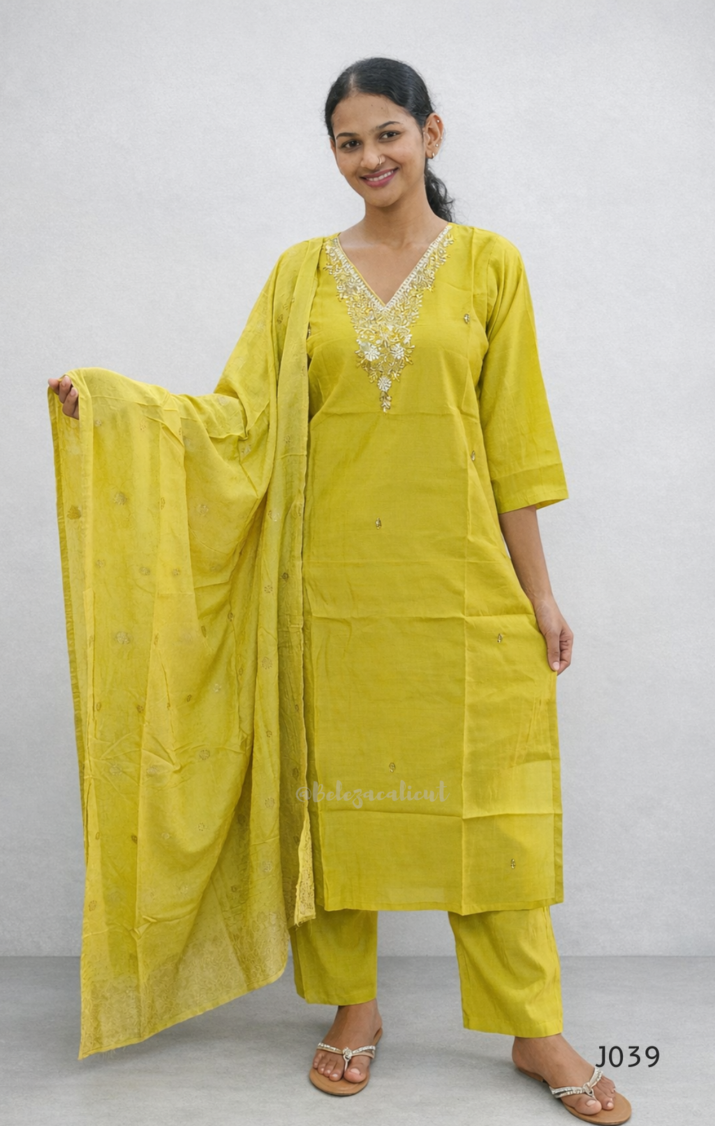 Woman wearing a yellow traditional outfit with a plain background