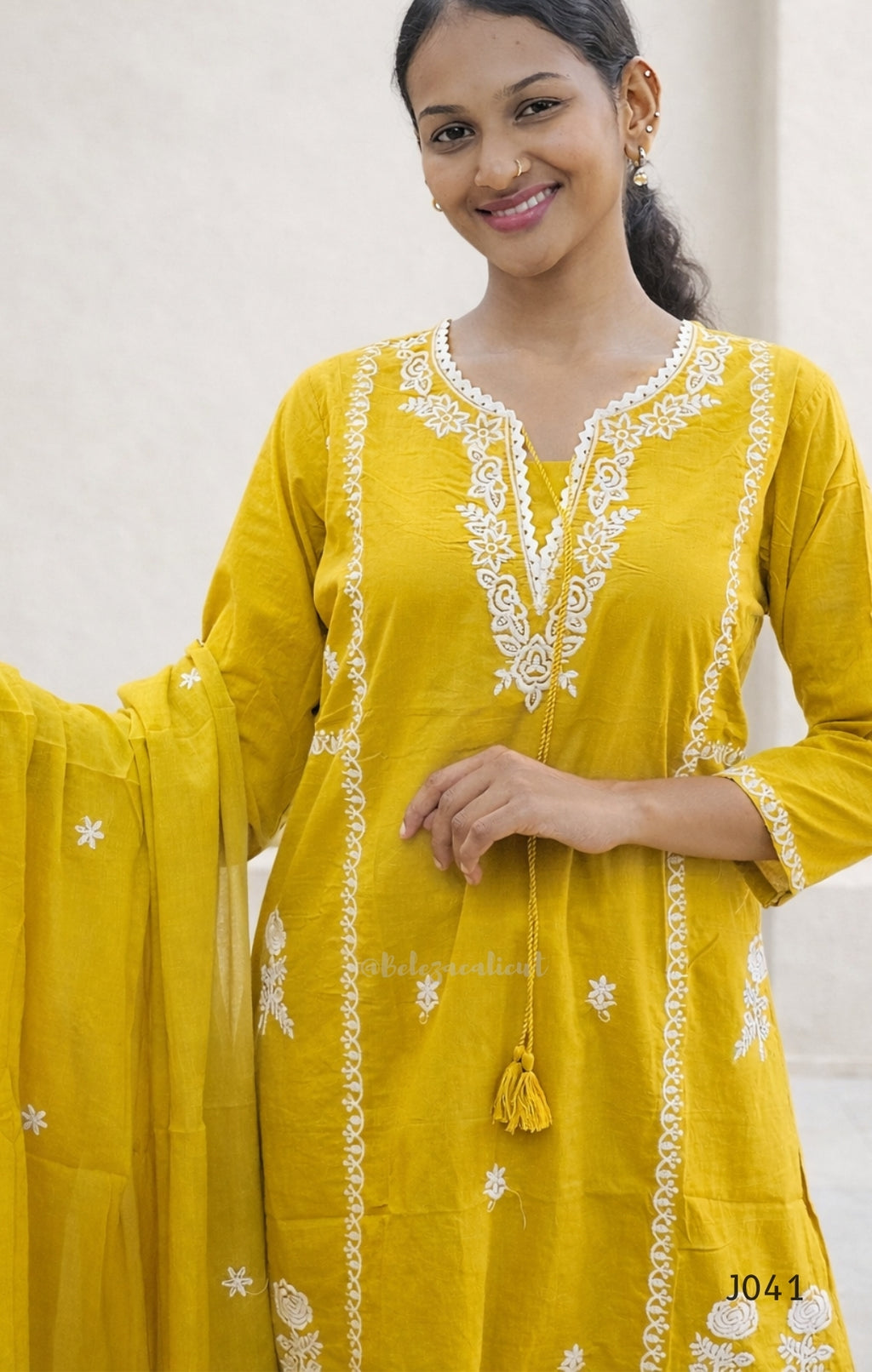Woman wearing a yellow embroidered kurta with a white background