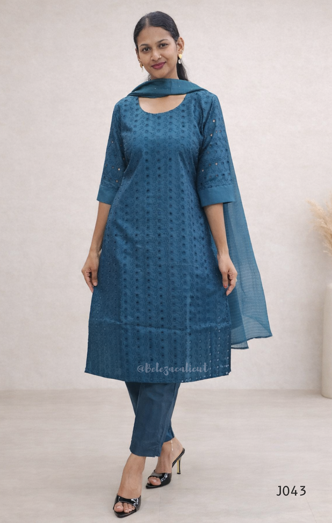Woman wearing a blue kurta with a matching dupatta against a plain background