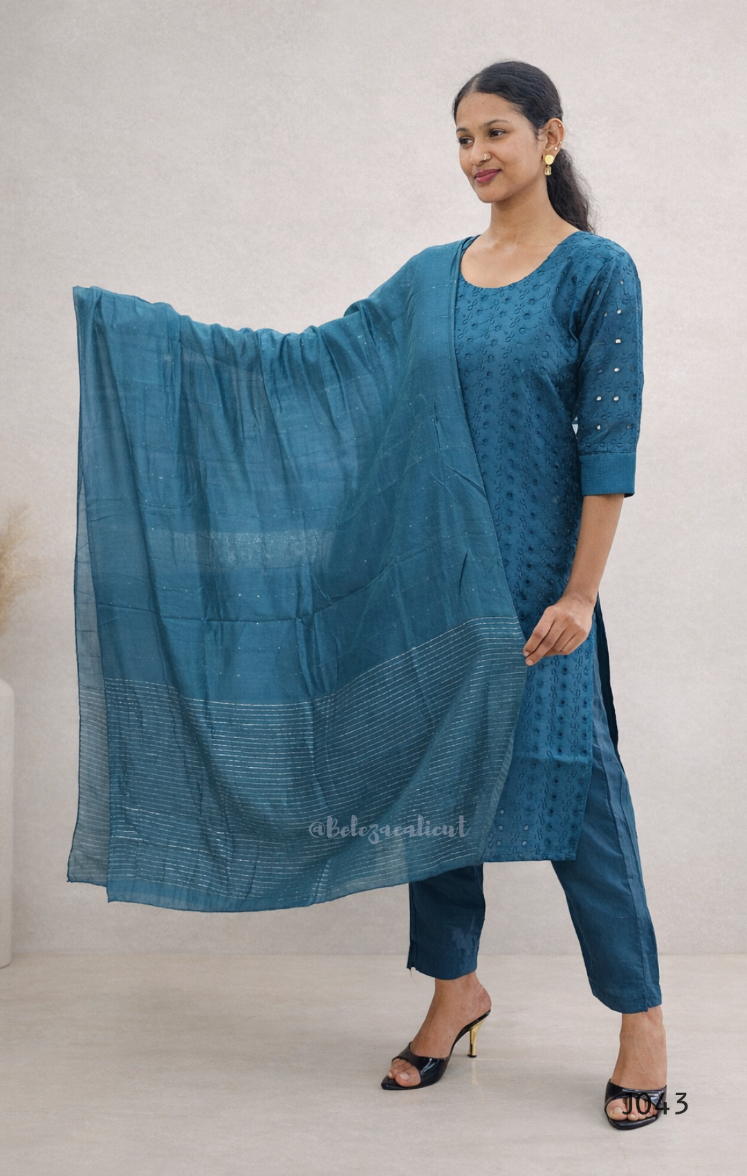 Woman wearing a blue traditional outfit with a plain background