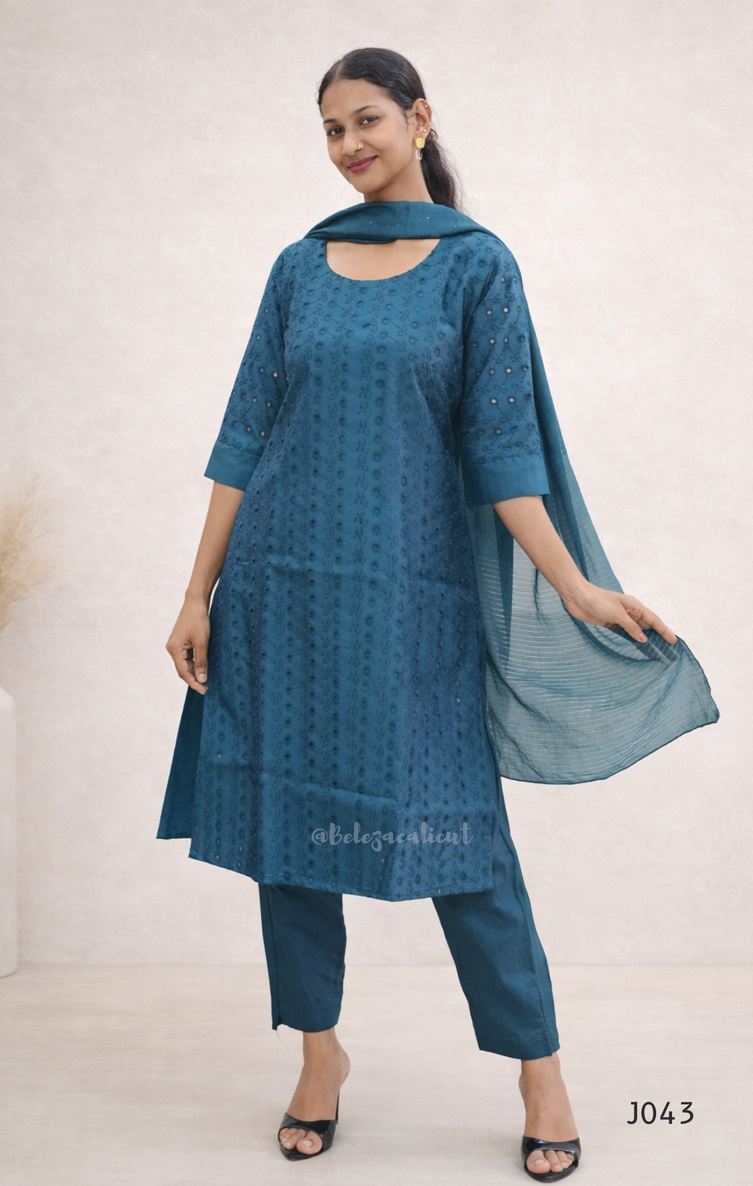 Woman wearing a blue kurta with matching pants on a white background