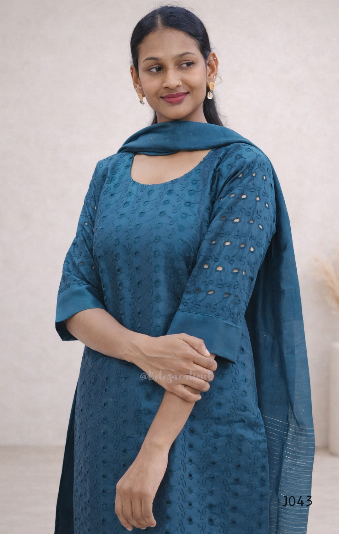 Woman wearing a blue traditional outfit with a plain background