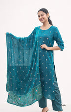 Woman wearing a teal traditional outfit with a matching dupatta on a white background