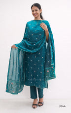 Woman wearing a teal traditional outfit with a matching dupatta on a white background