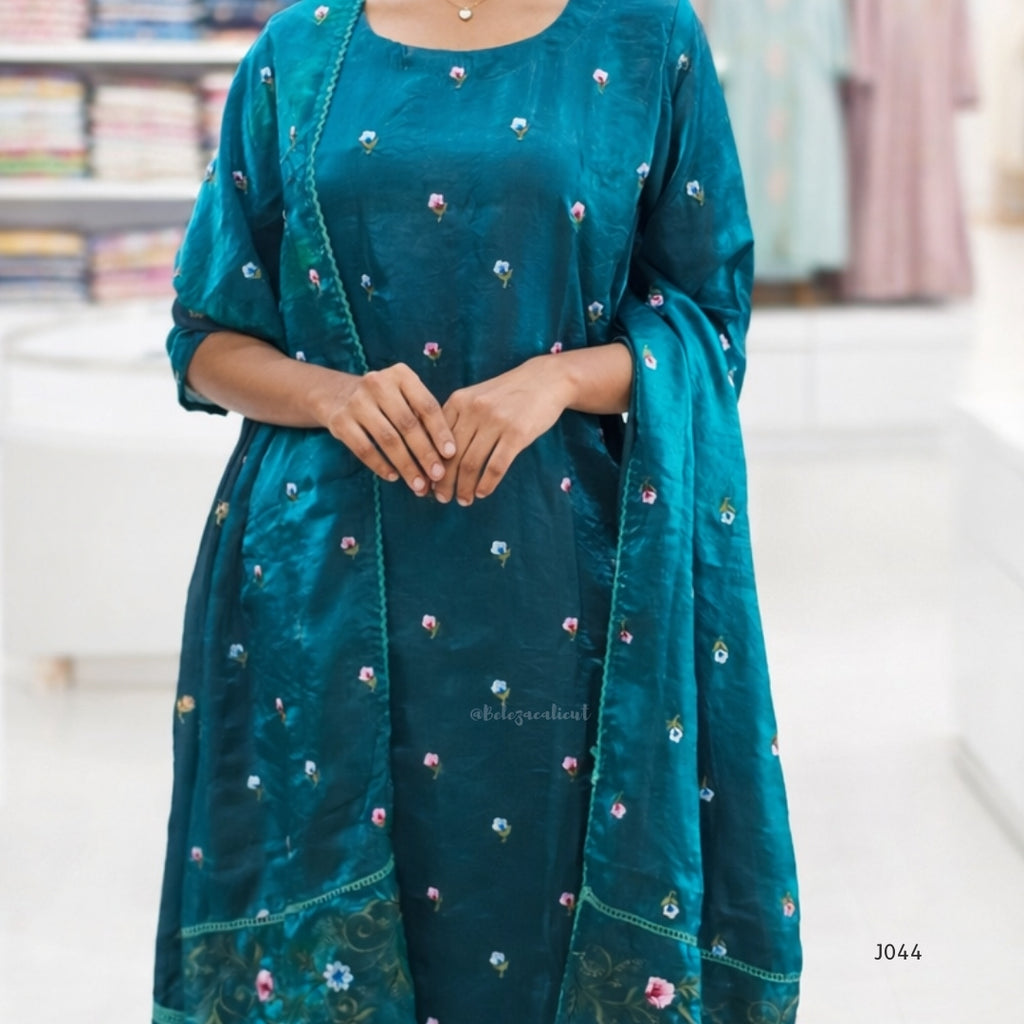 Teal traditional outfit with floral embroidery on a blurred background