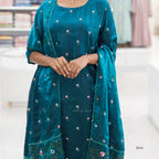 Teal traditional outfit with floral embroidery on a blurred background