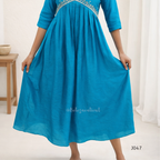 Blue dress with embellishments on a plain background