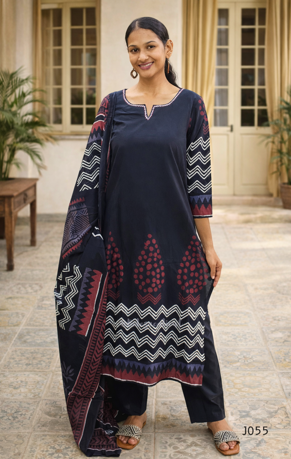 Woman wearing a black kurta with patterned sleeves and border, standing outdoors.