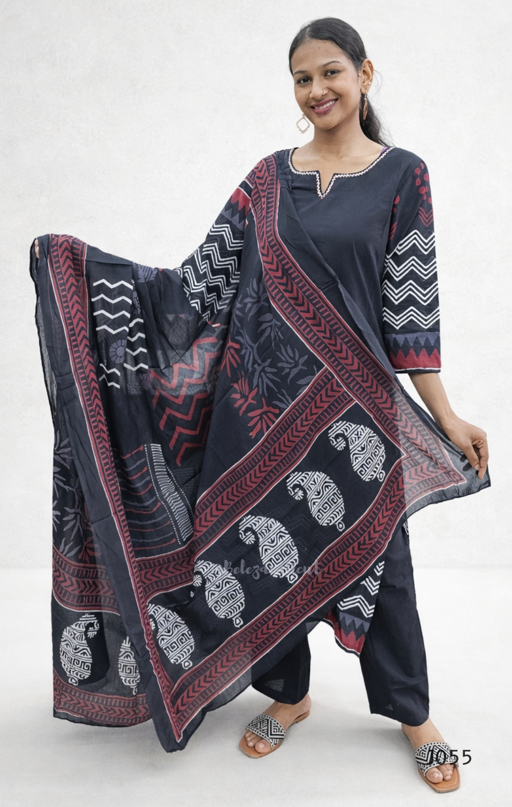 Woman holding a large black and red patterned scarf on a white background
