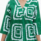 Green dress with white geometric pattern on a plain background