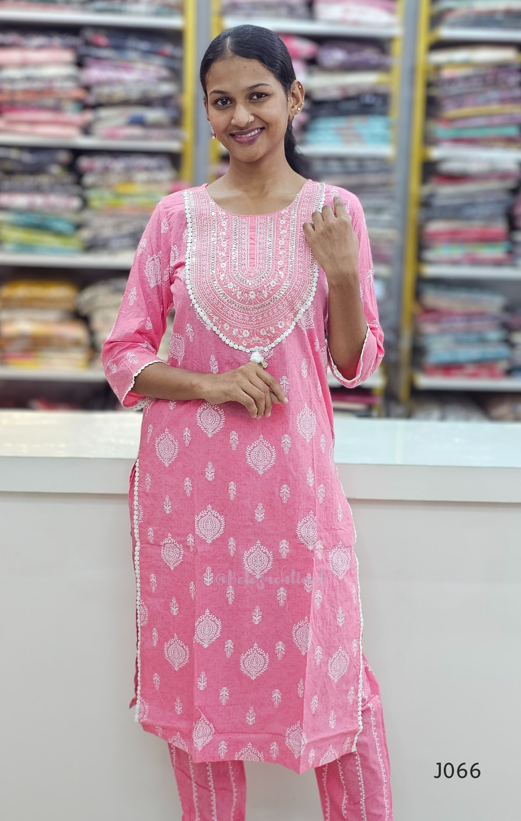 Woman wearing a pink embroidered kurta in a fabric store