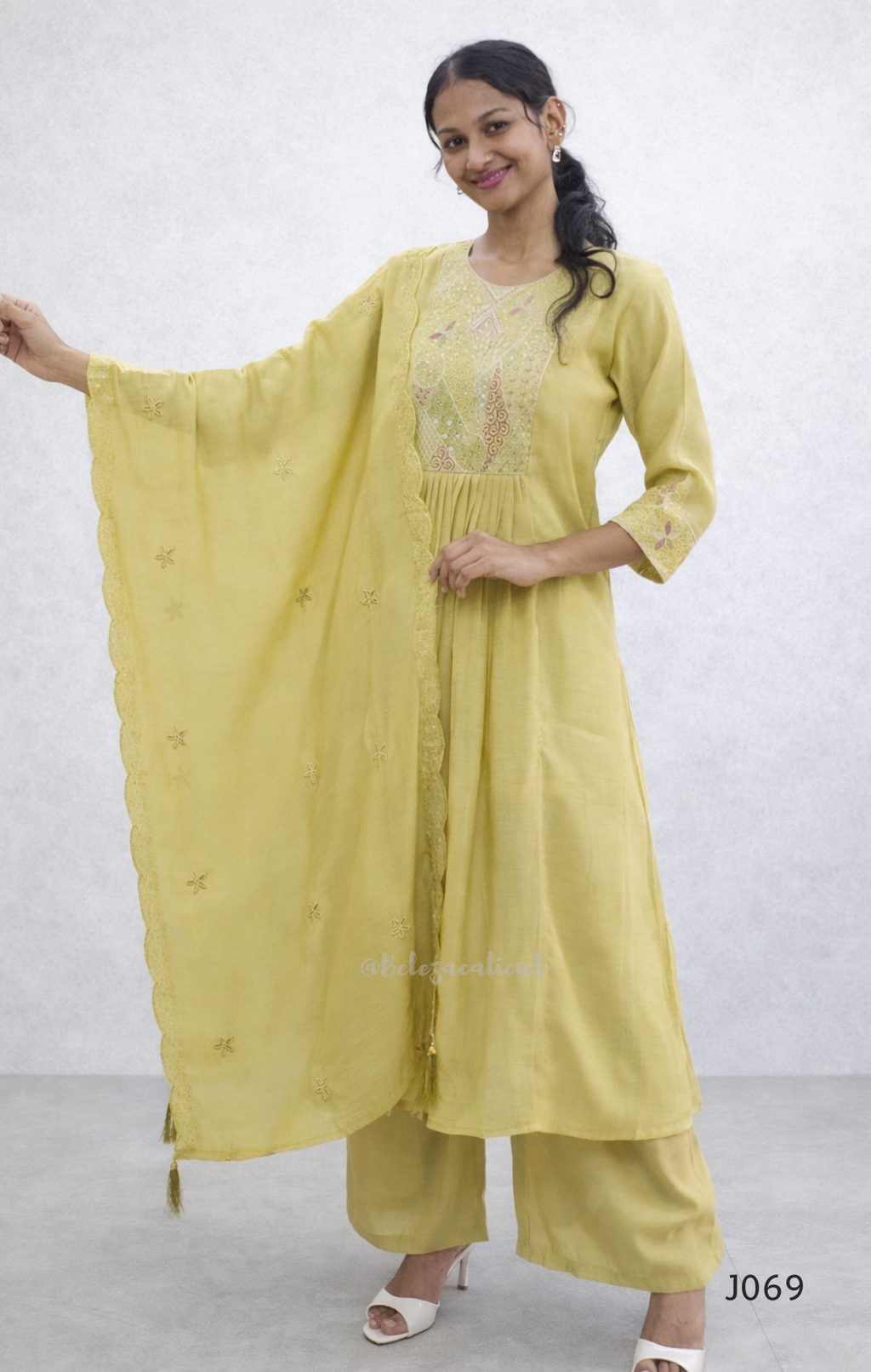 Woman wearing a yellow traditional outfit with a white background