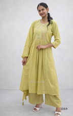 Woman wearing a light green traditional outfit with a plain background