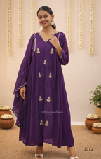 Woman wearing a purple dress with gold embroidery in a decorated indoor setting.