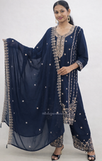 Woman wearing a navy blue traditional outfit with intricate gold embroidery on a white background