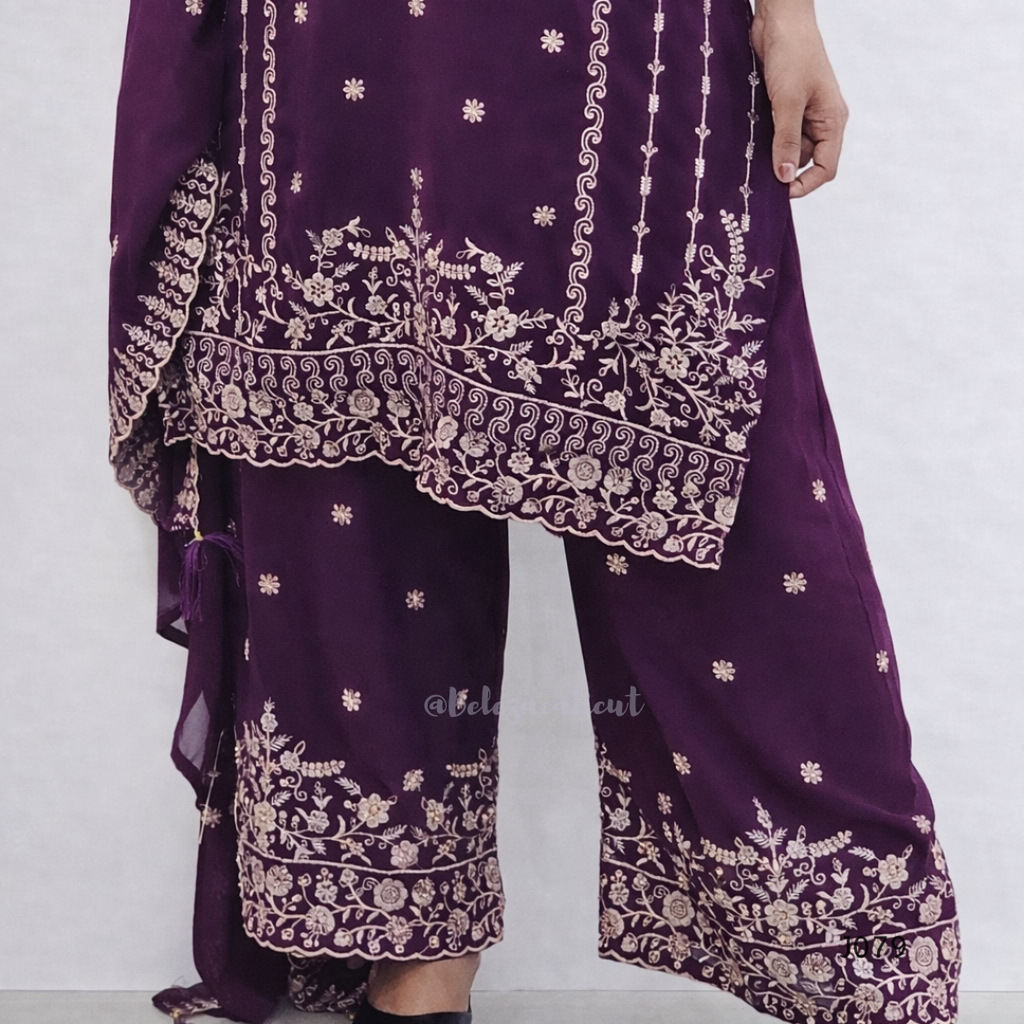 Purple traditional outfit with intricate white embroidery on a white background