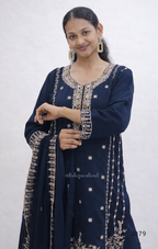 Woman wearing a navy blue traditional outfit with gold embroidery against a white background
