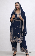 Woman wearing a navy blue embroidered outfit with a white background