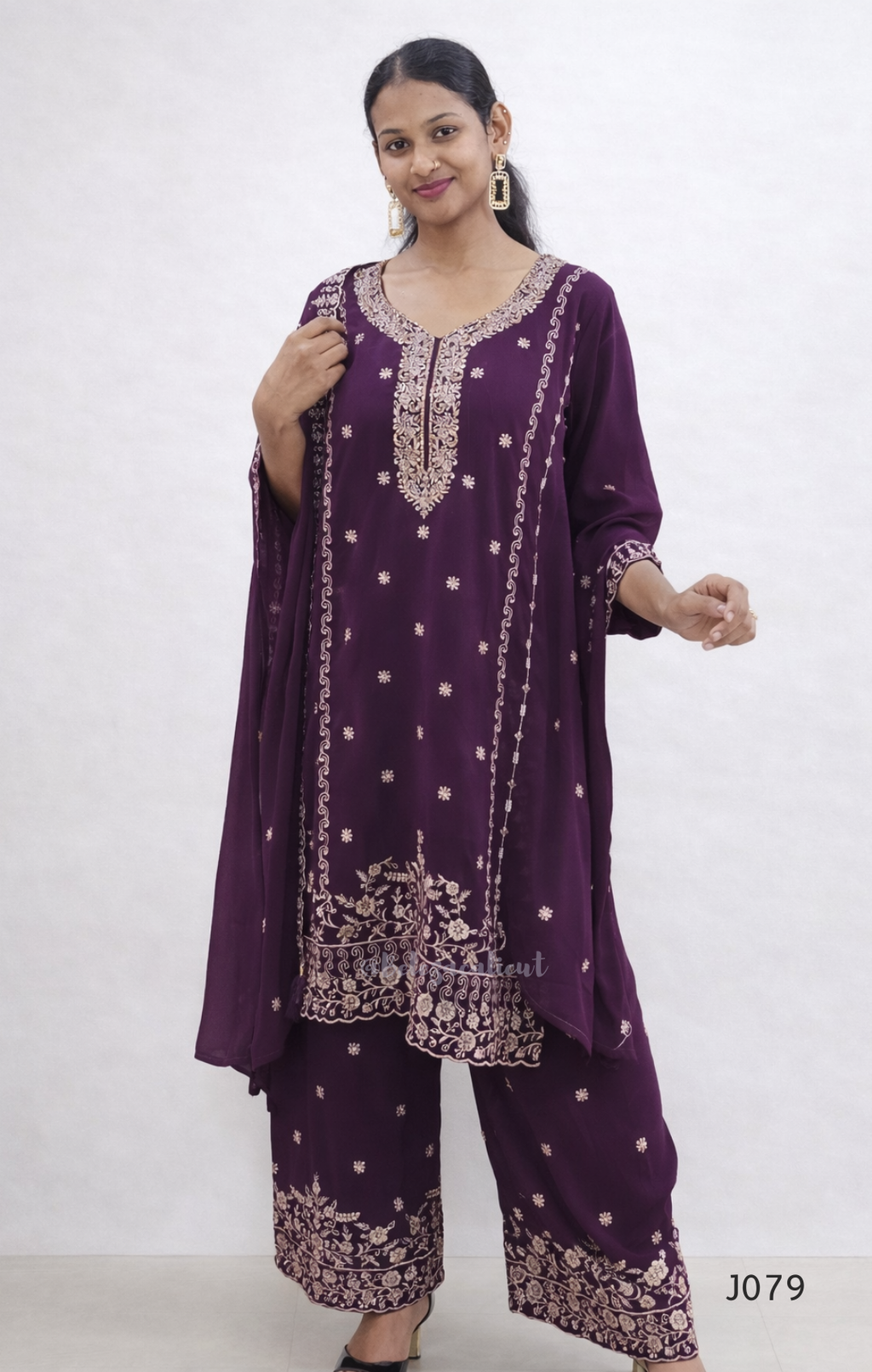 Woman wearing a purple embroidered outfit on a white background