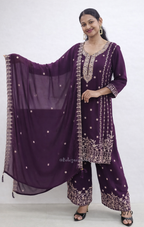 Woman wearing a purple traditional outfit with intricate designs on a white background