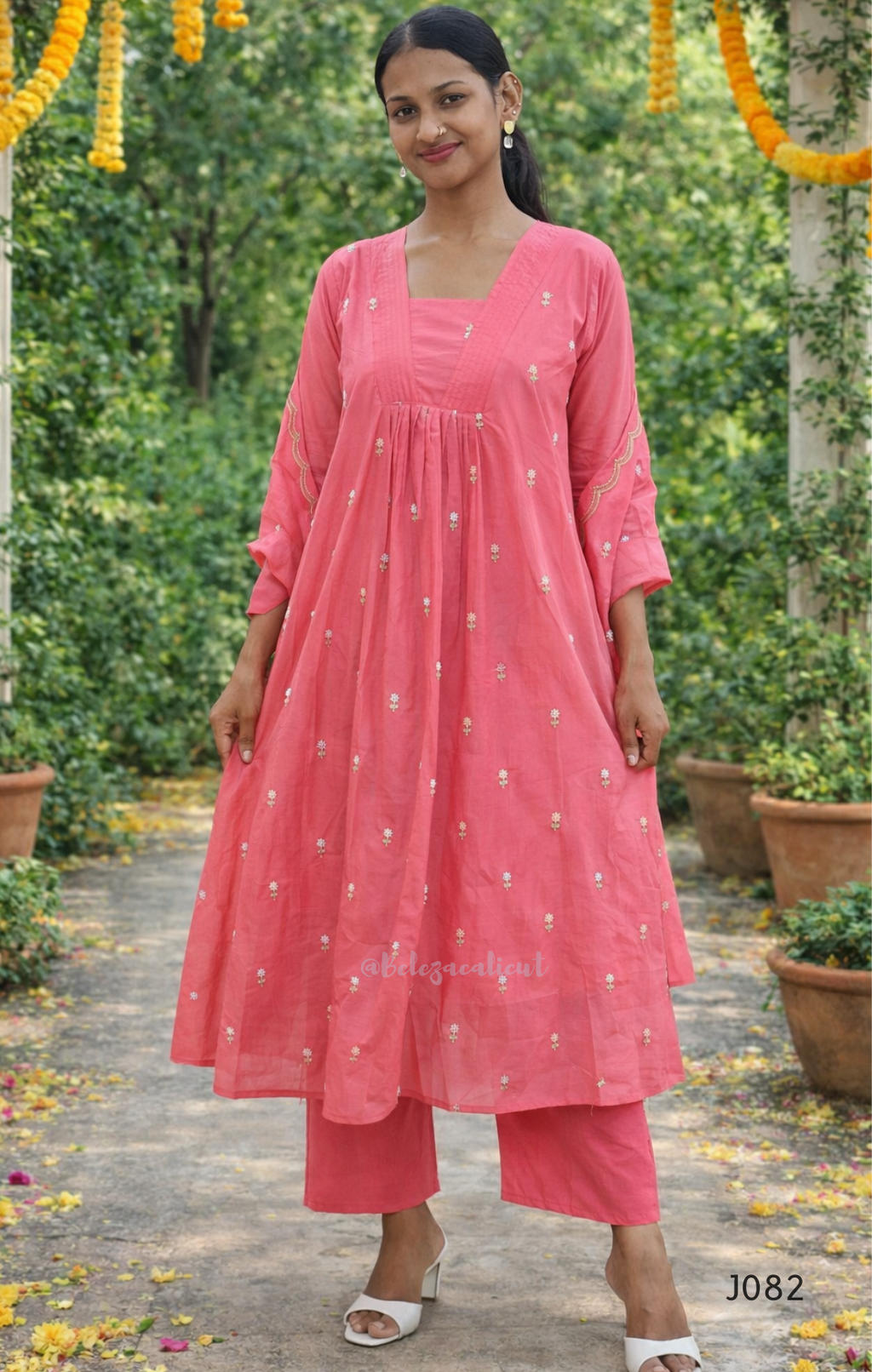 Woman wearing a pink traditional outfit with a garden background