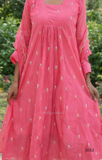 Pink traditional outfit with gold embroidery against a blurred natural background