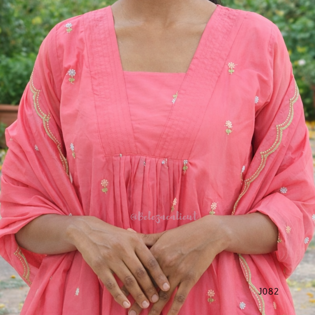 Close-up of a person wearing a pink traditional outfit with floral embroidery.