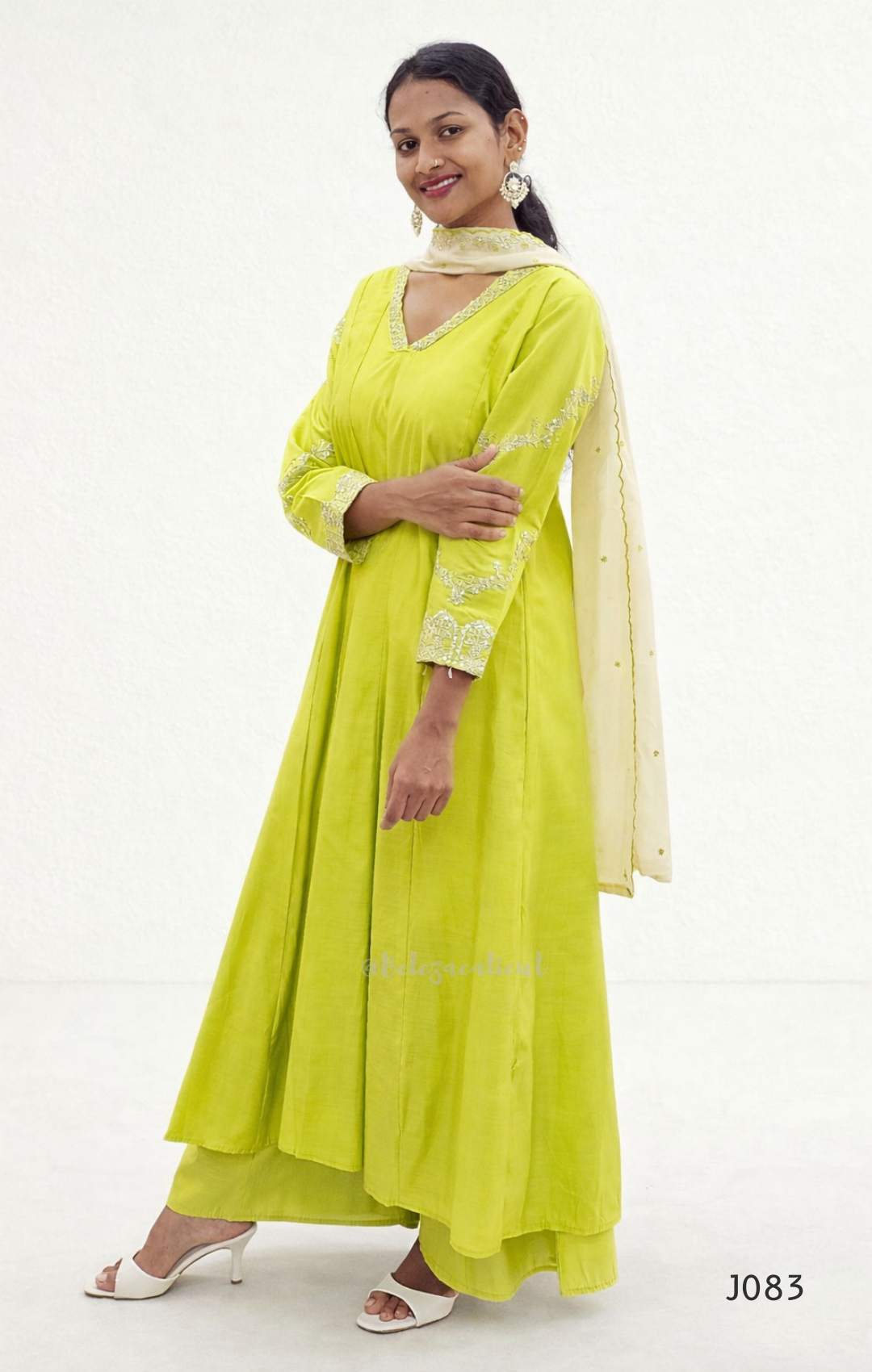 Woman wearing a bright yellow traditional outfit with a white background