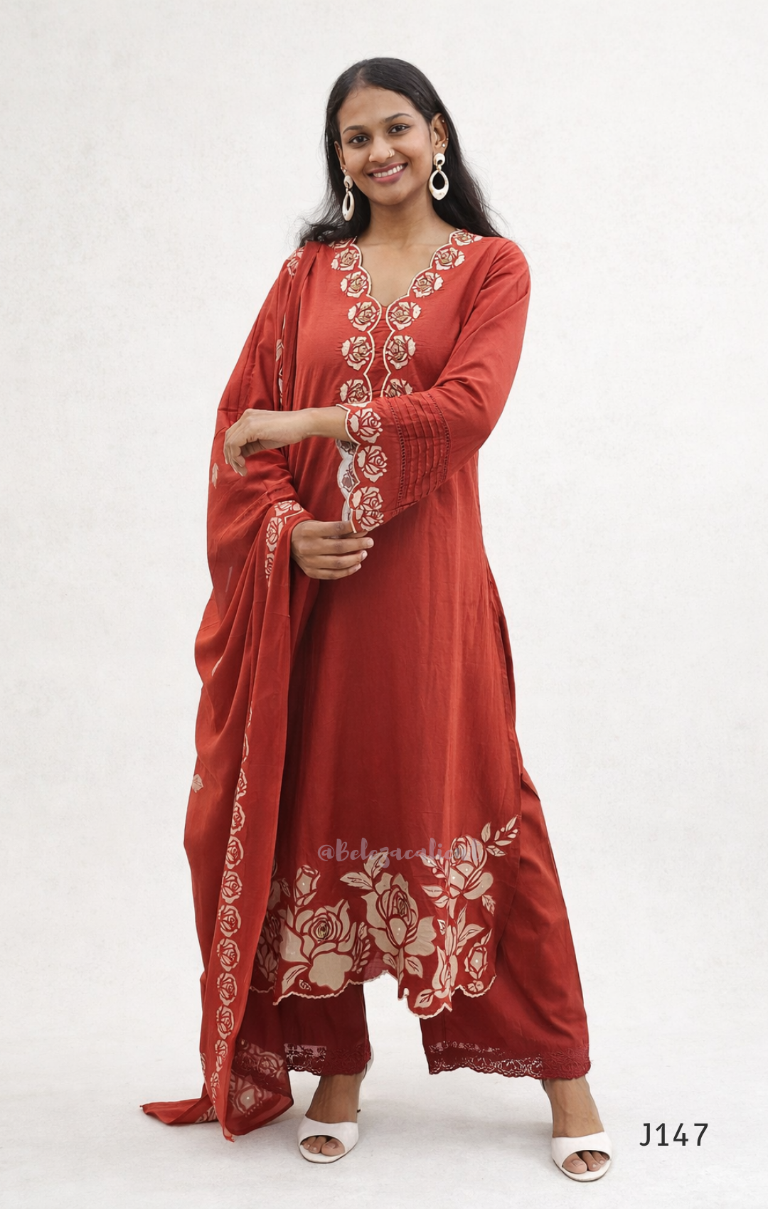 Woman wearing a red embroidered traditional outfit on a white background