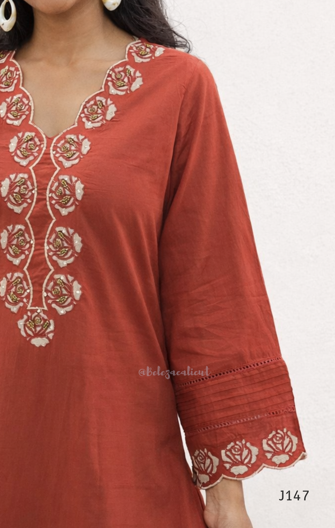 Red kurta with white floral embroidery on a white background