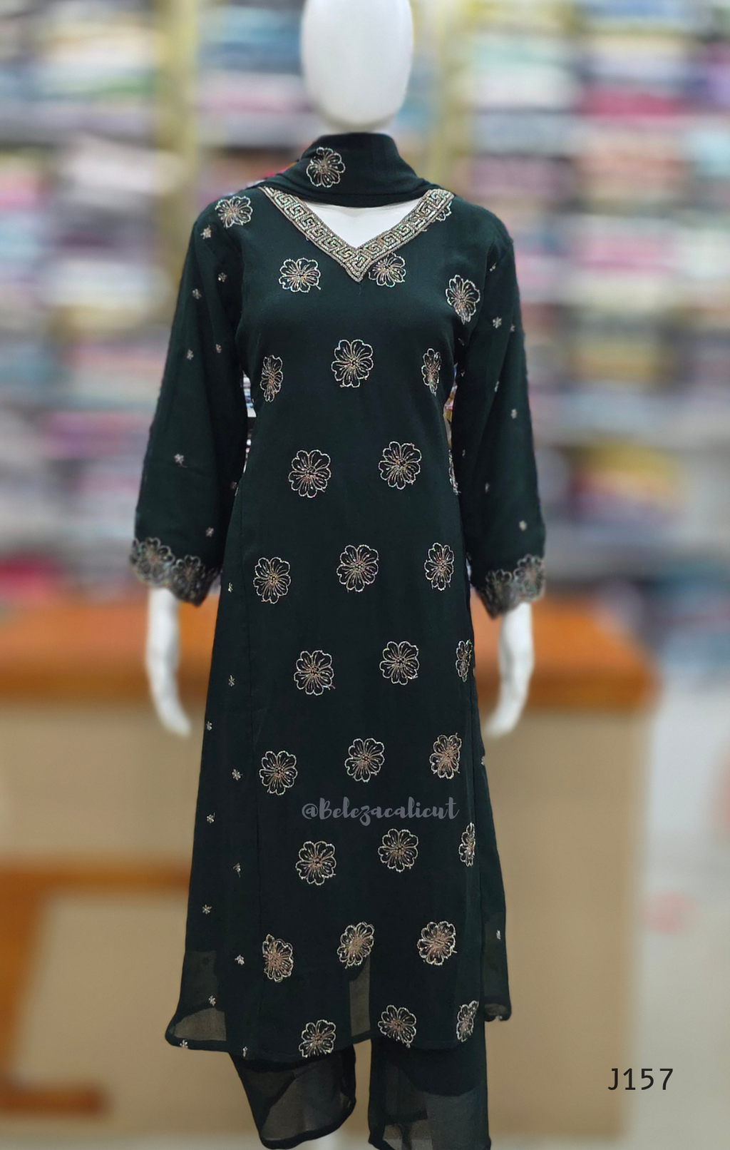 Black embroidered dress on a mannequin with a blurred background