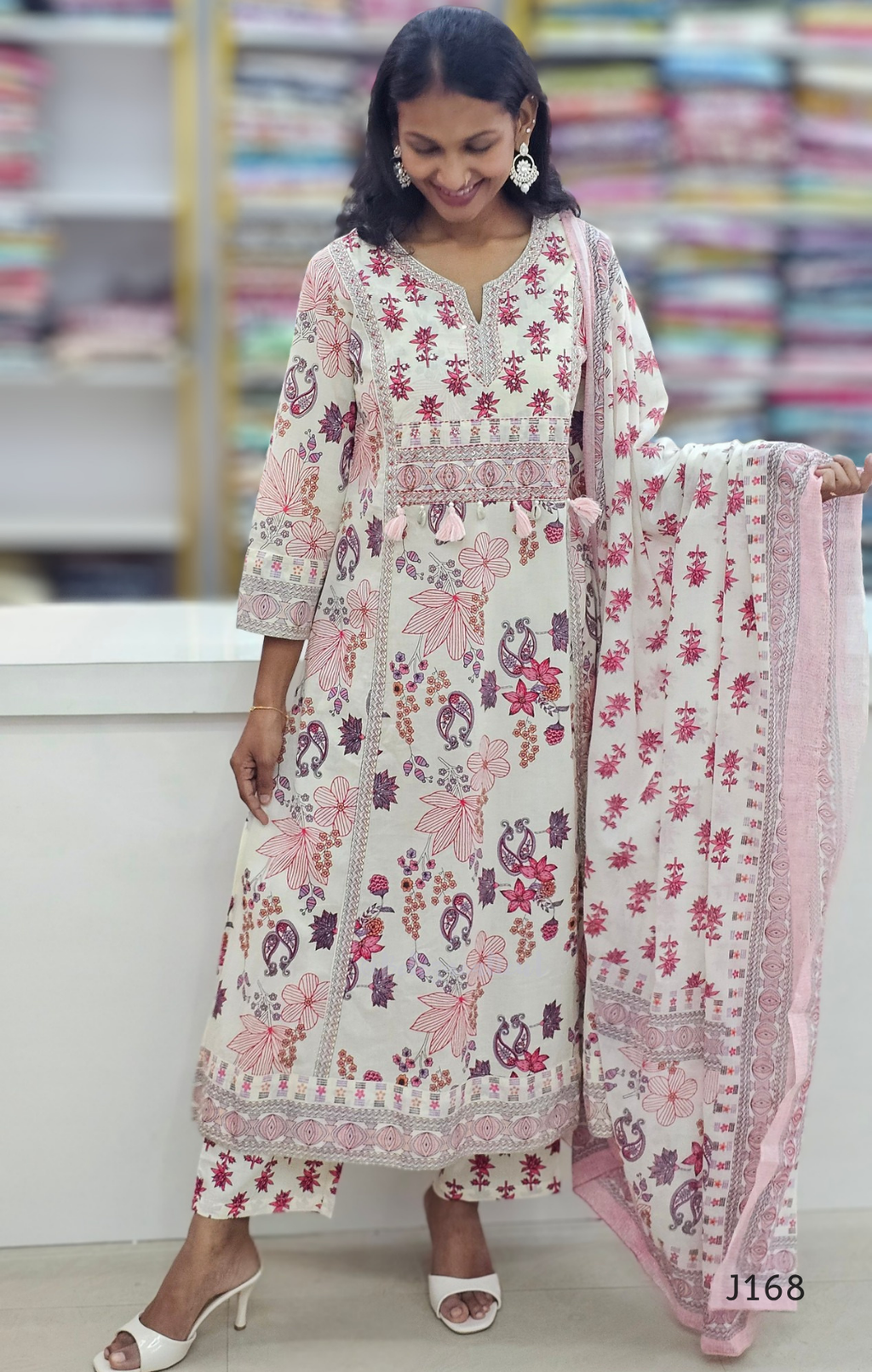 Woman wearing a floral dress with a matching dupatta in a store setting